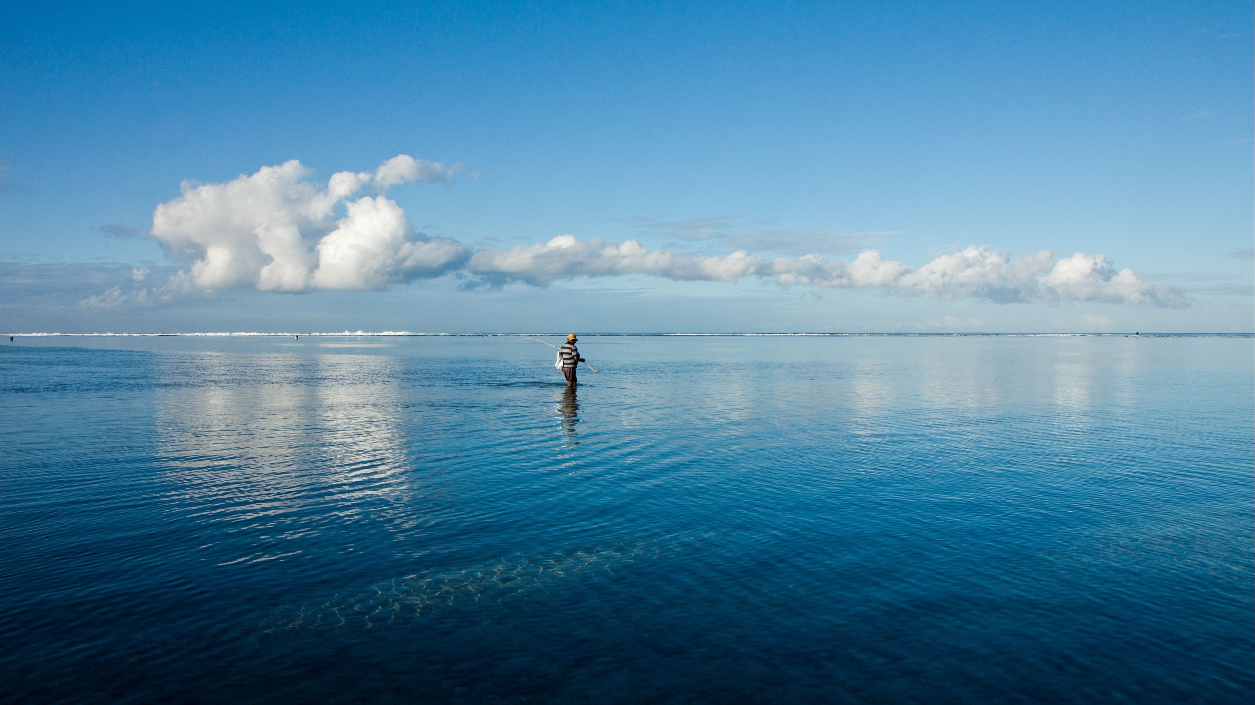 person in body of water under blue sky during daytime